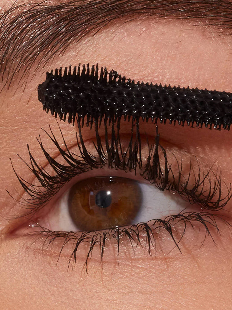 close up of model applying extravalash mascara to eyelashes