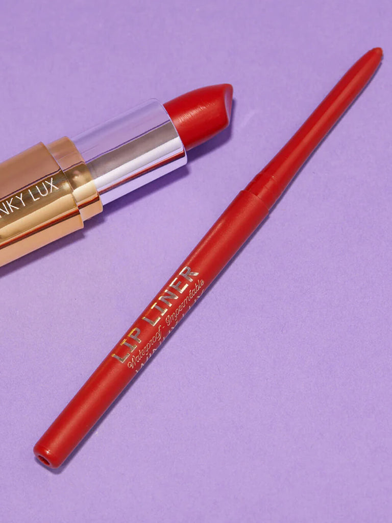 Dirty Love -- waterproof lip liner and lipstick in red shade lying next to each other on purple background