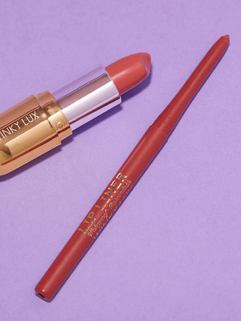 Meow -- waterproof lip liner and lipstick in mauve shade lying next to each other on purple background