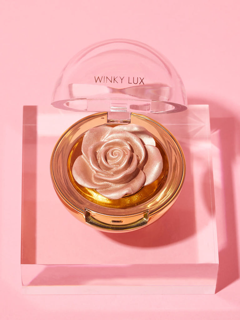 Champagne -- Cheeky Rose Cream highlighter on clear platform on pink background