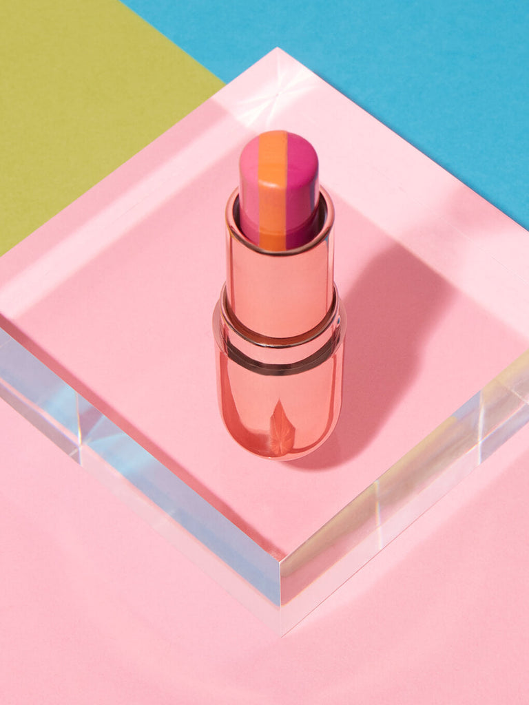 sorbet tinted lip balm standing up on glass surface