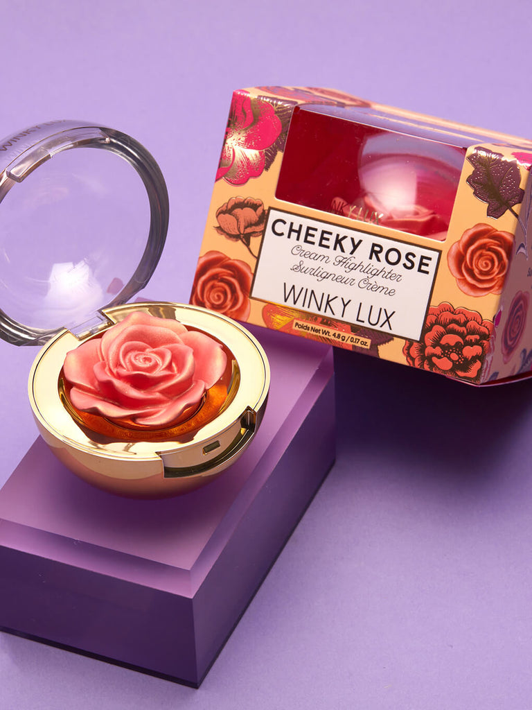Rosé -- cheeky rose cream highlighter propped up next to box on purple background