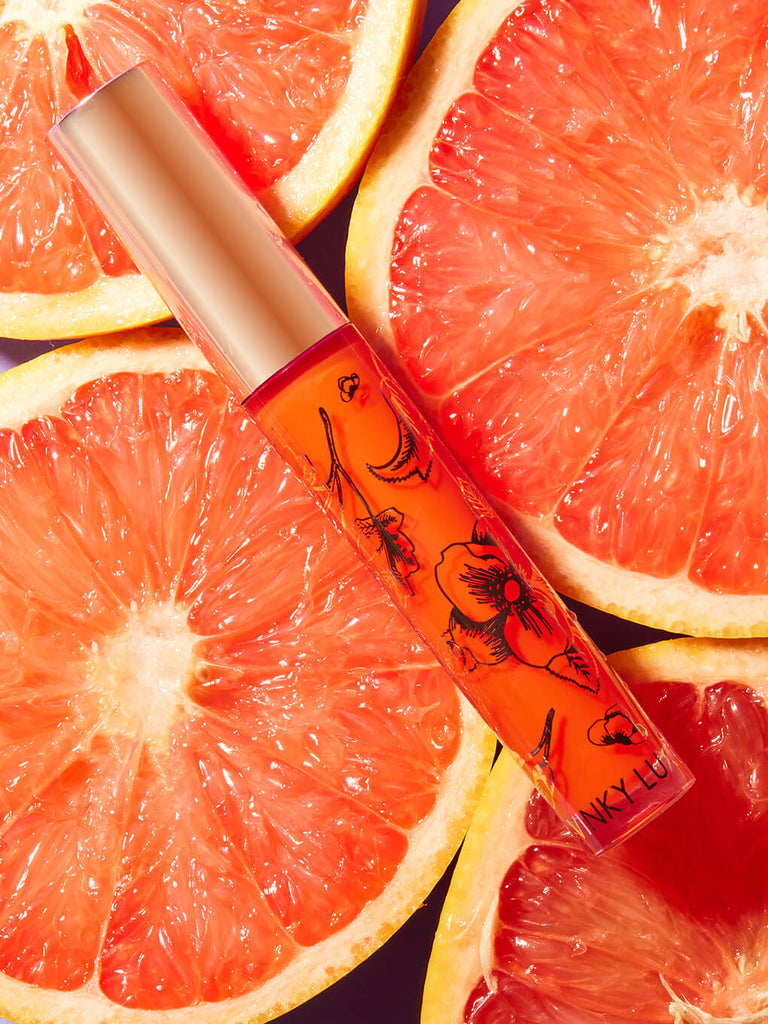 grapefruit -- fruity ph lip gloss resting on bed of grapefruits