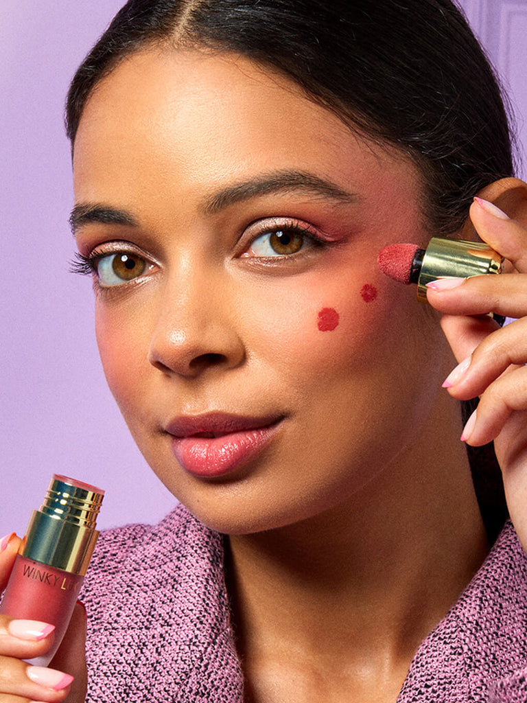Darling -- model applying cheeky rose liquid blush on cheeks