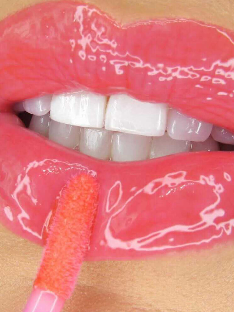 grapefruit -- close up of model applying ph lip gloss on lips