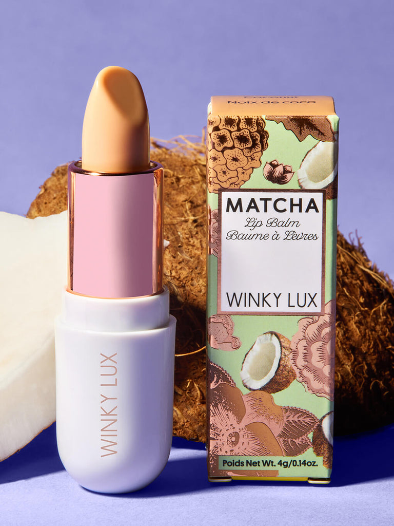 coconut -- matcha lip balm and box standing up in front coconut on purple backgrround