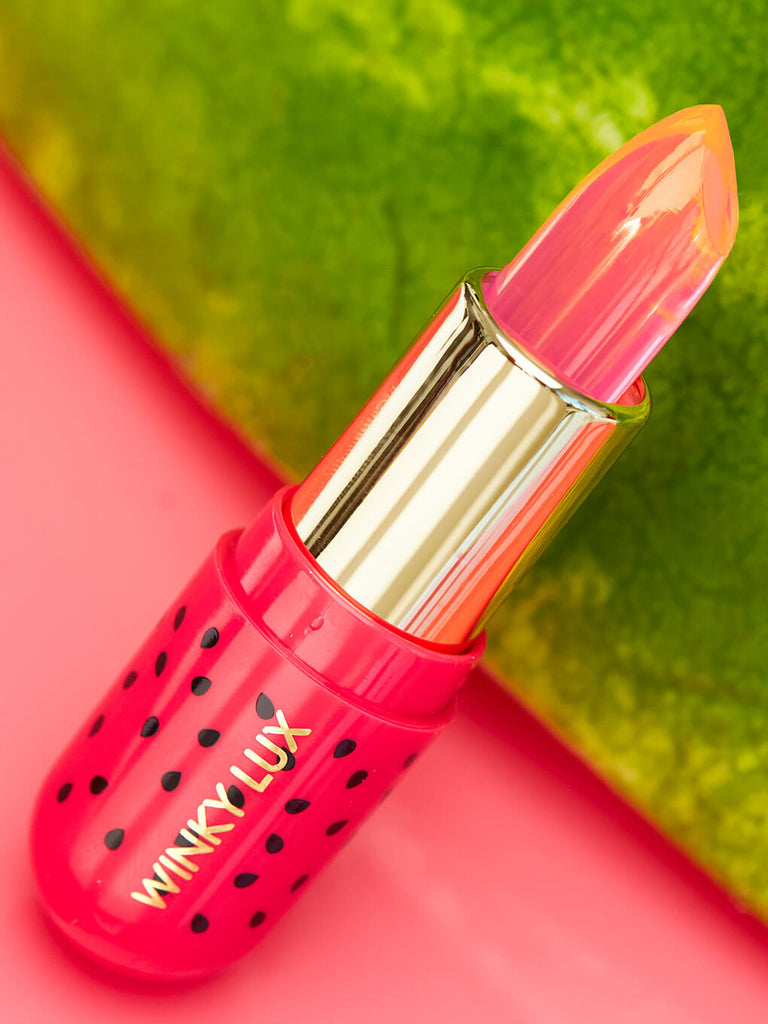 close up on watermelon jelly ph lip balm with watermelon in the background