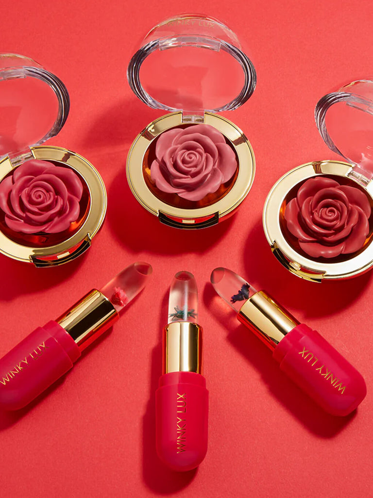 set of flower ph lip balms and cheeky rose cream blushes on red background