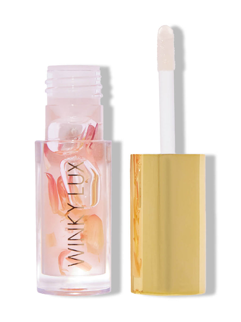 flower petal nourishing lip oil with cap off on white background