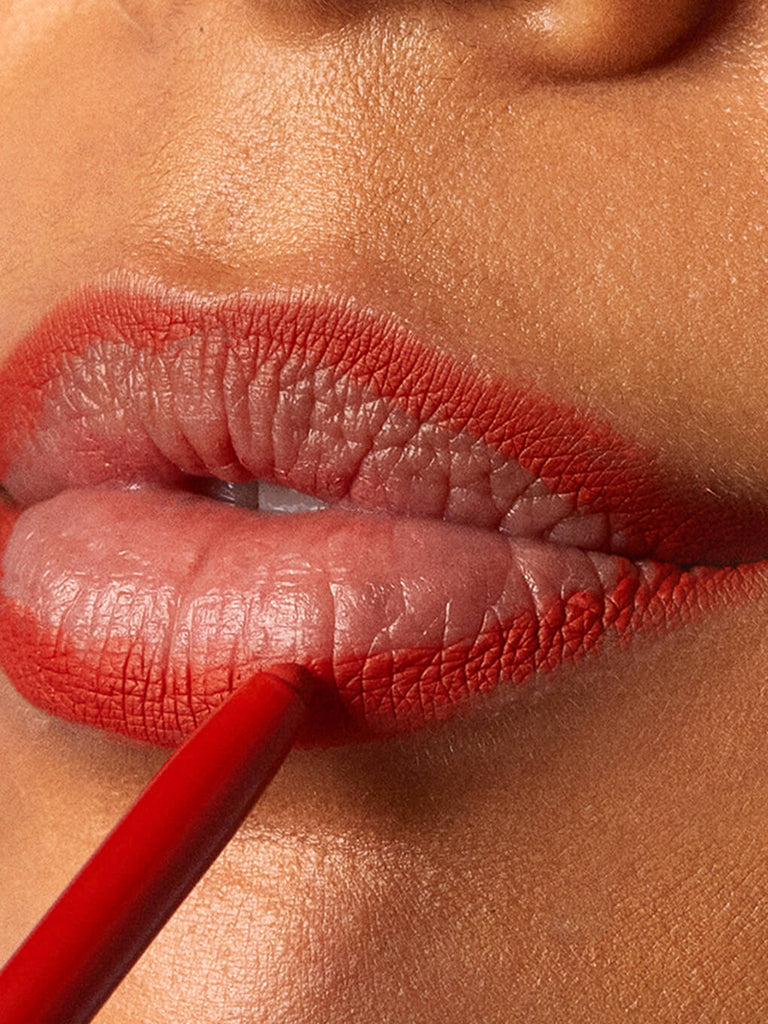 dirty love -- close up of brunette model applying waterproof lip liner