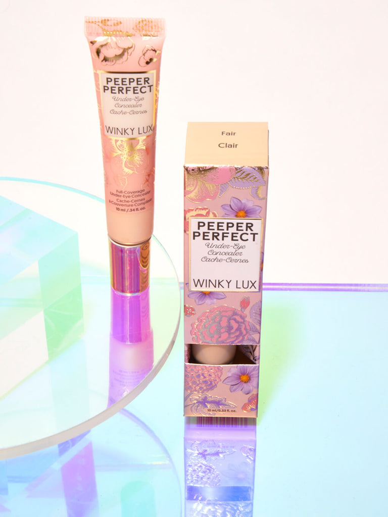 Fair -- peeper perfect under eye concealer next to box with shiny props