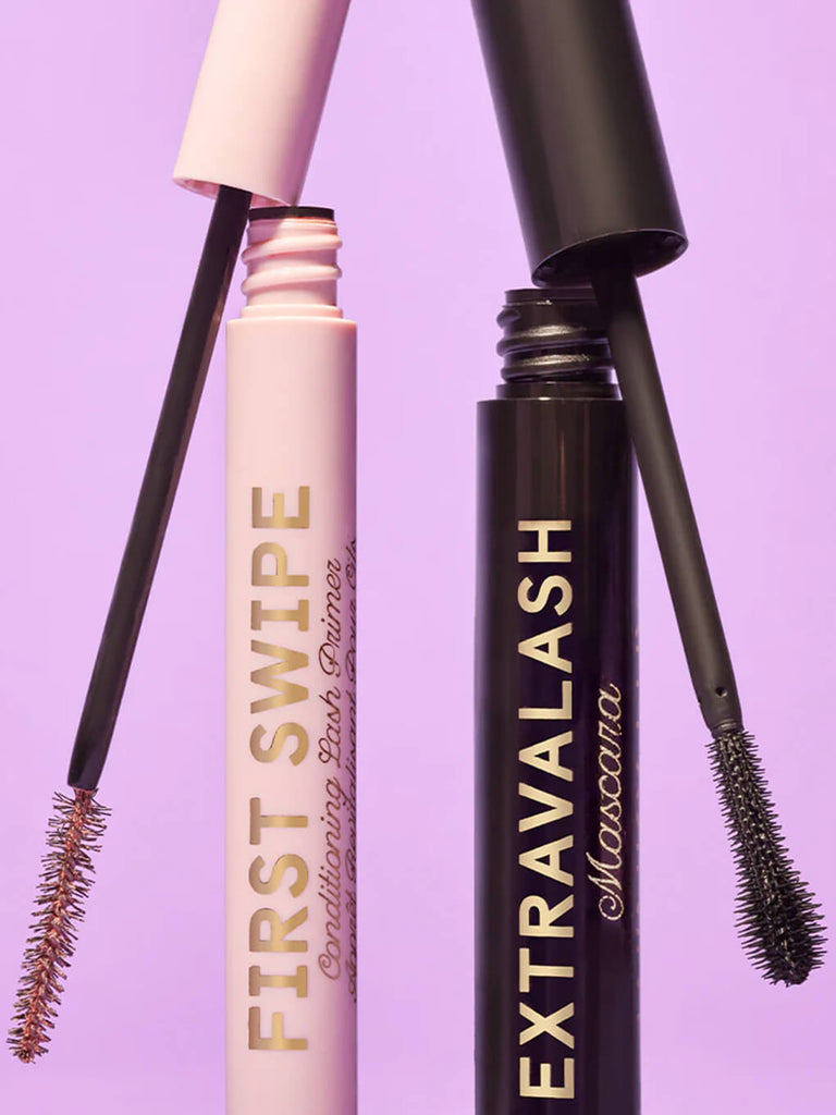 first swipe conditioning lash primer and extravalash mascara standing up with caps leaning on top