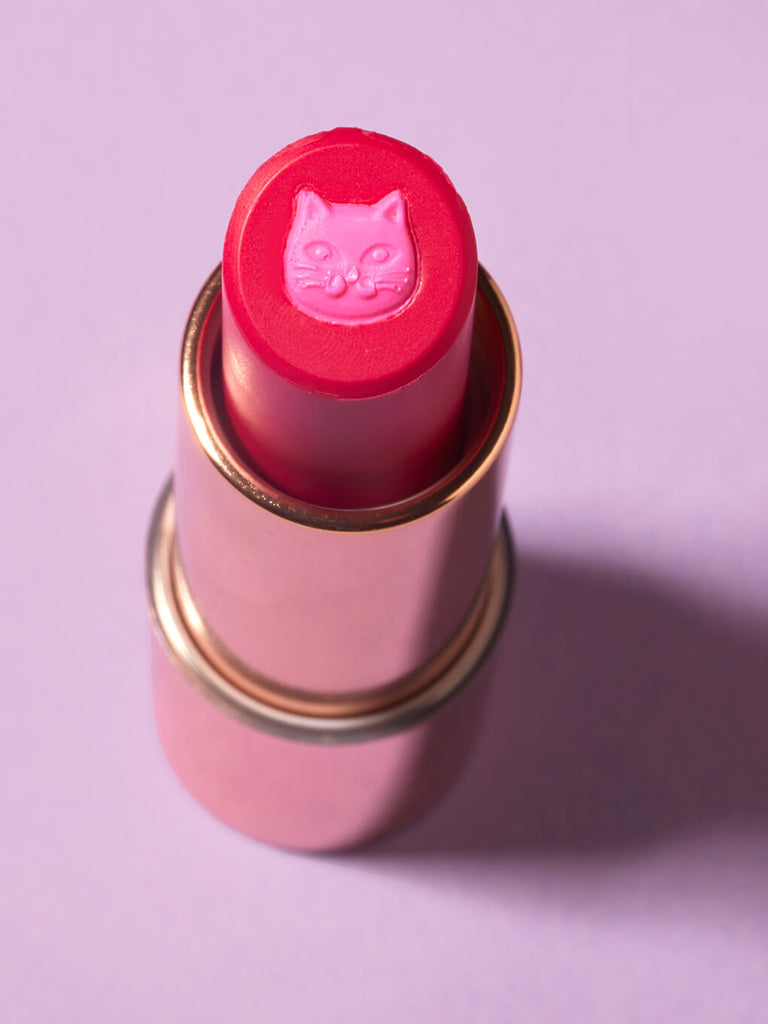 Kiss & Tail -- purrfect pout sheer lipstick standing up close up of cat stamp on purple background