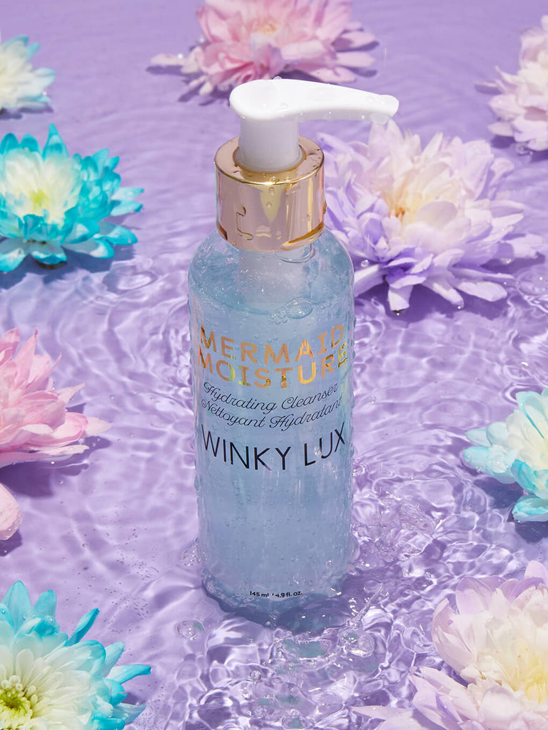 mermaid moisture hydrating face cleanser sitting in water surrounded by flowers