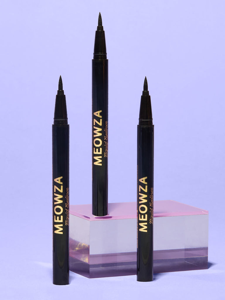 meowza liquid eyeliner standing on glass surface with purple background 