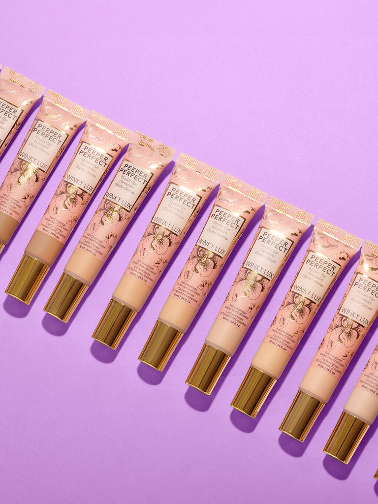Light/Beige -- all shades of peeper perfect under eye concealer lined up on purple background