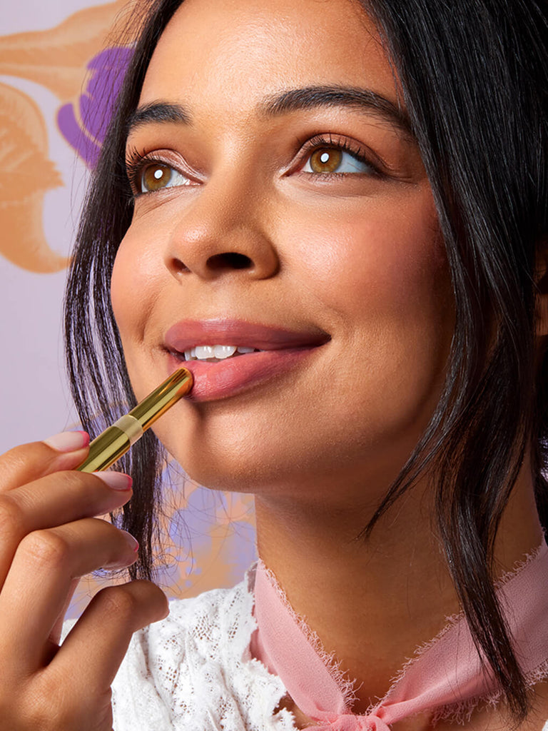 honey baby -- close up of brunette model applying skinny plump demi matte plumping lipstick