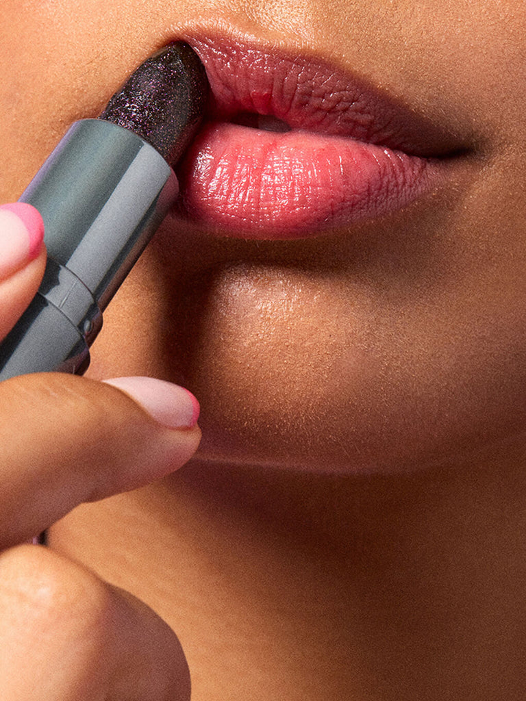 close up of model applying aurora ph lip balm to lips