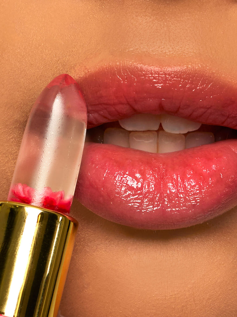 pink -- close up of model applying flower ph lip balm to lips