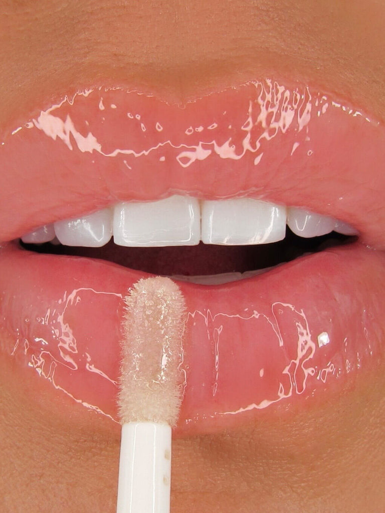 close up of flower petal nourishing lip oil applying to lips