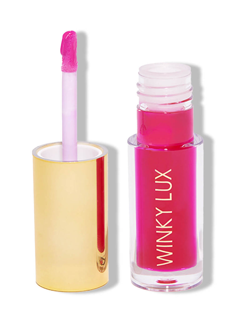 luscious -- barely there tinted lip oil with cap next to bottle on white background