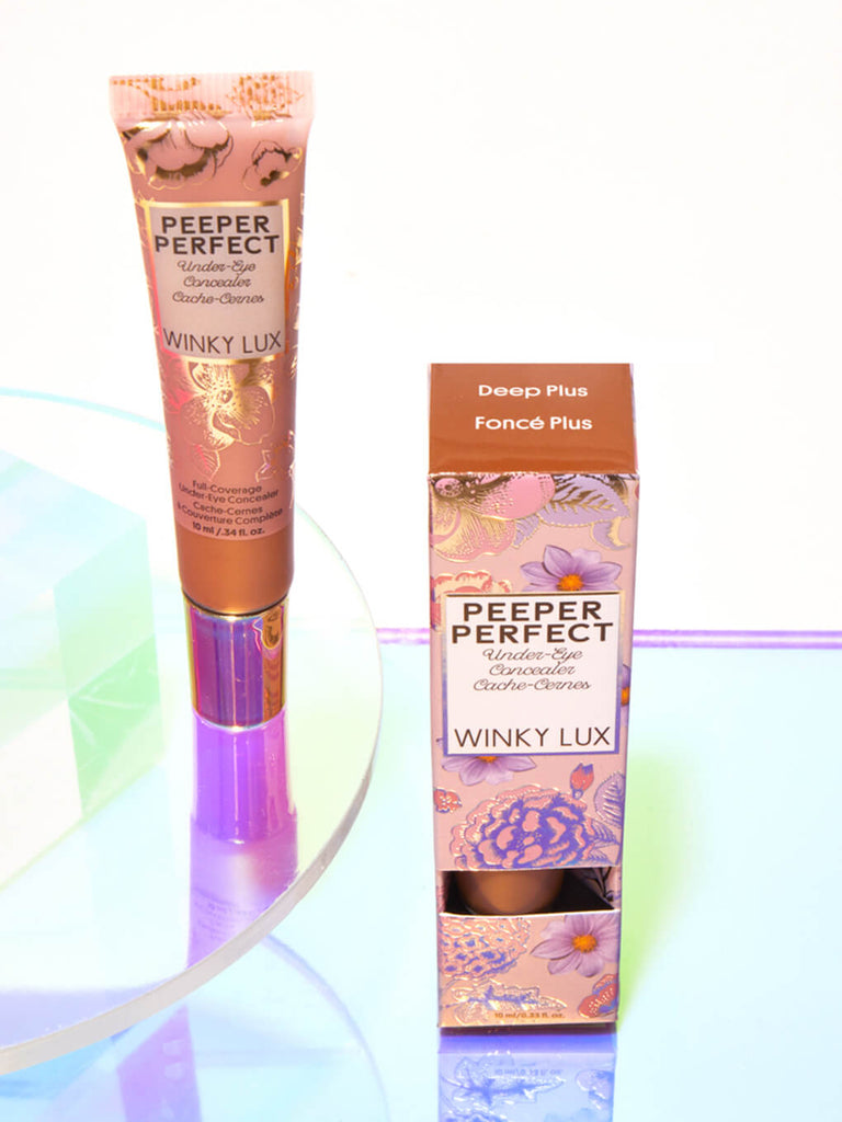 Deep/Plus -- peeper perfect under eye concealer next to box with shiny props