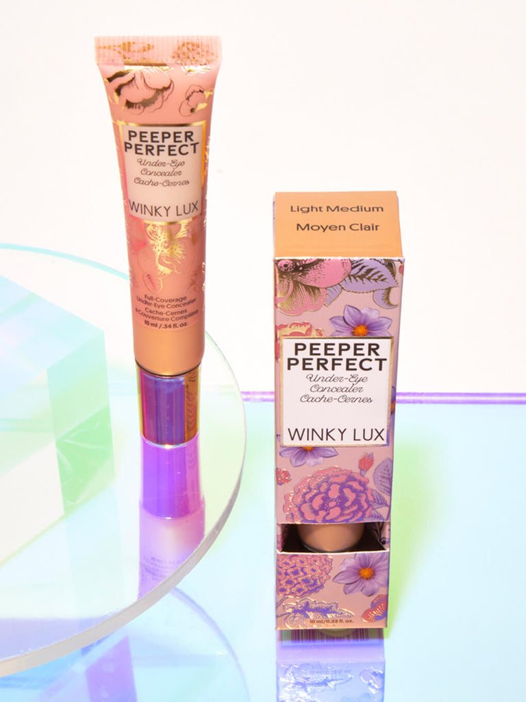 Light/Medium -- peeper perfect under eye concealer next to box with shiny props