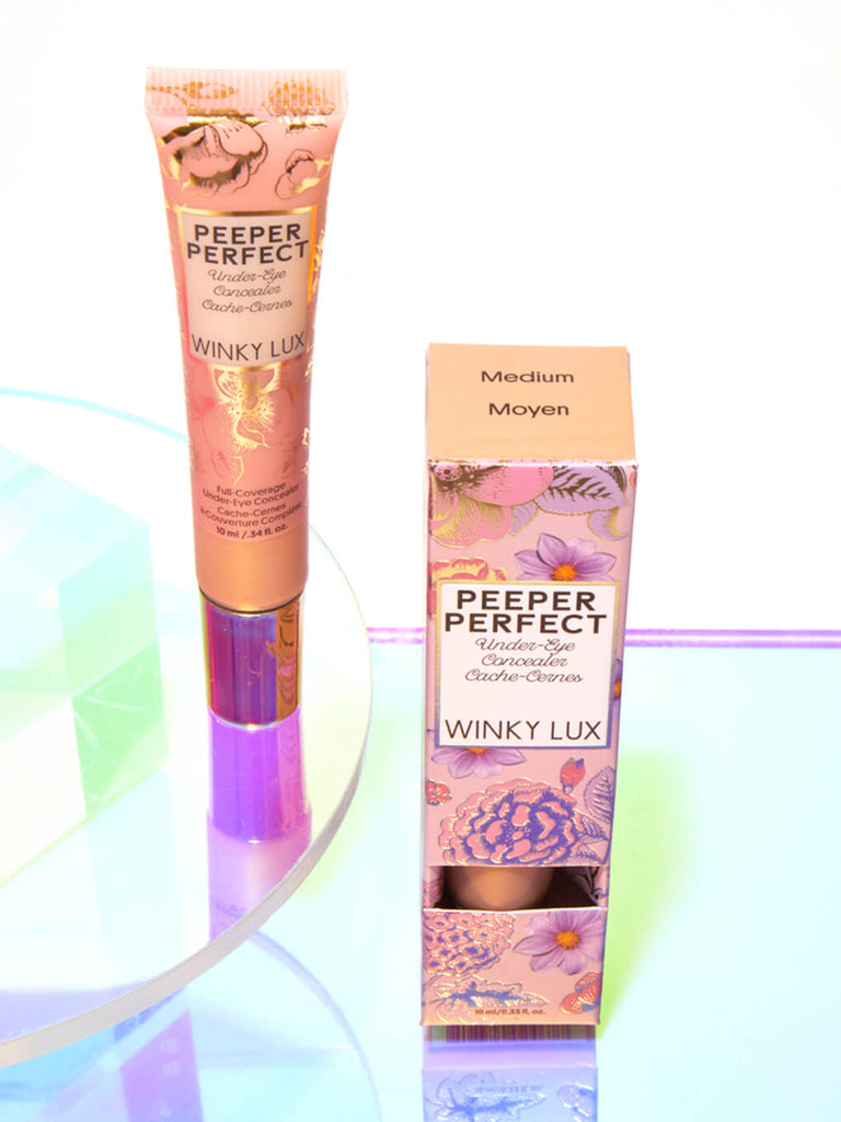 Medium -- peeper perfect under eye concealer next to box with shiny props