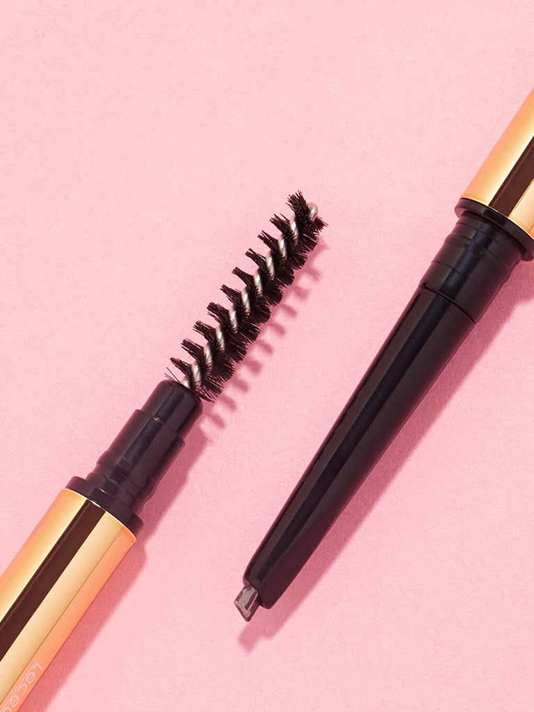 flat lay of two unibrow precision brow pencils on pink background