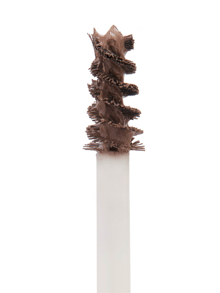 close up of mini unibrow tinted brow gel brush on white background 