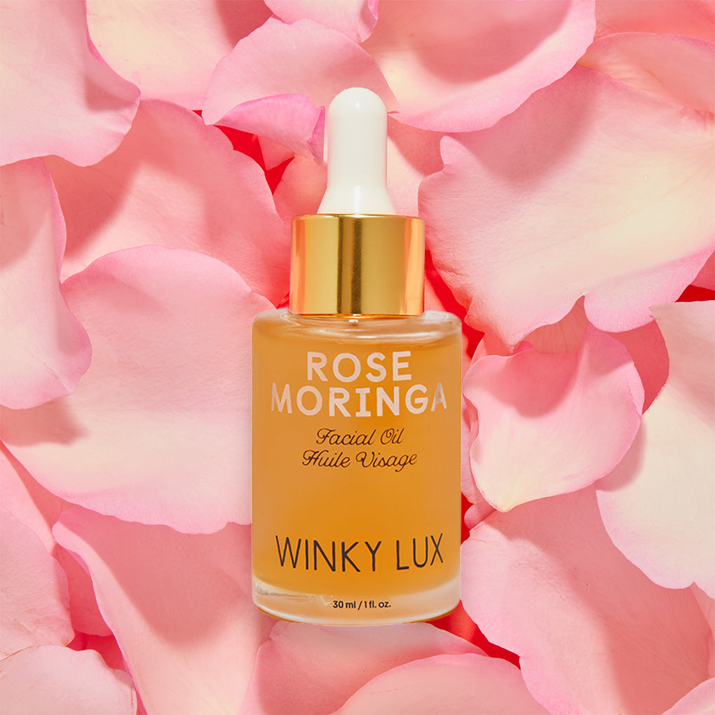 So Quenched Skincare Trio -- rose moringa facial oil laying in bed of pink petals